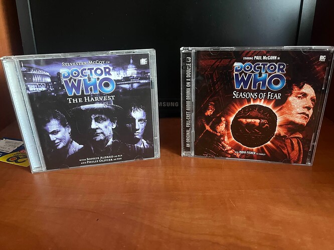 The image shows two Doctor Who audio drama CDs: "The Harvest" featuring Sylvester McCoy and "Seasons of Fear" starring Paul McGann. (Captioned by AI) (Actually not bad caption holy mama)