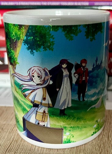 A mug features vibrant anime-style characters standing in a scenic, fantasy landscape. (Captioned by AI)