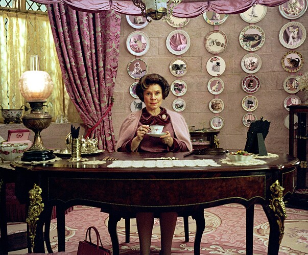 HP-F5-order-of-the-phoenix-umbridge-sat-at-desk-office-drinking-tea-smug-web-landscape